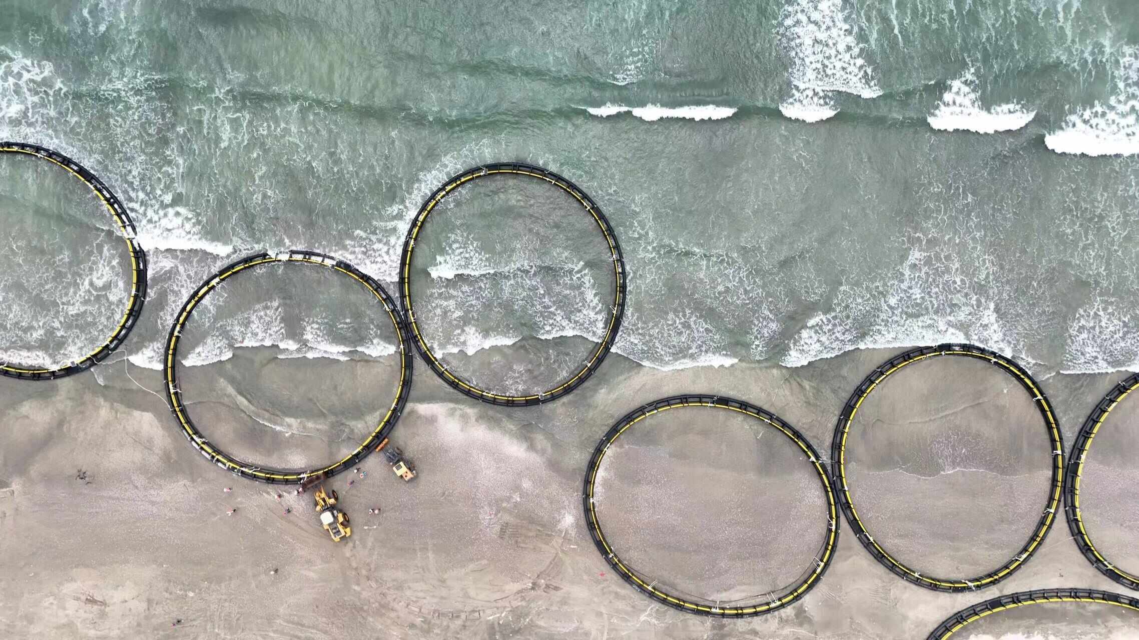 在海边正在被推入海中的“加强型重力式深水网箱” 通讯员供图