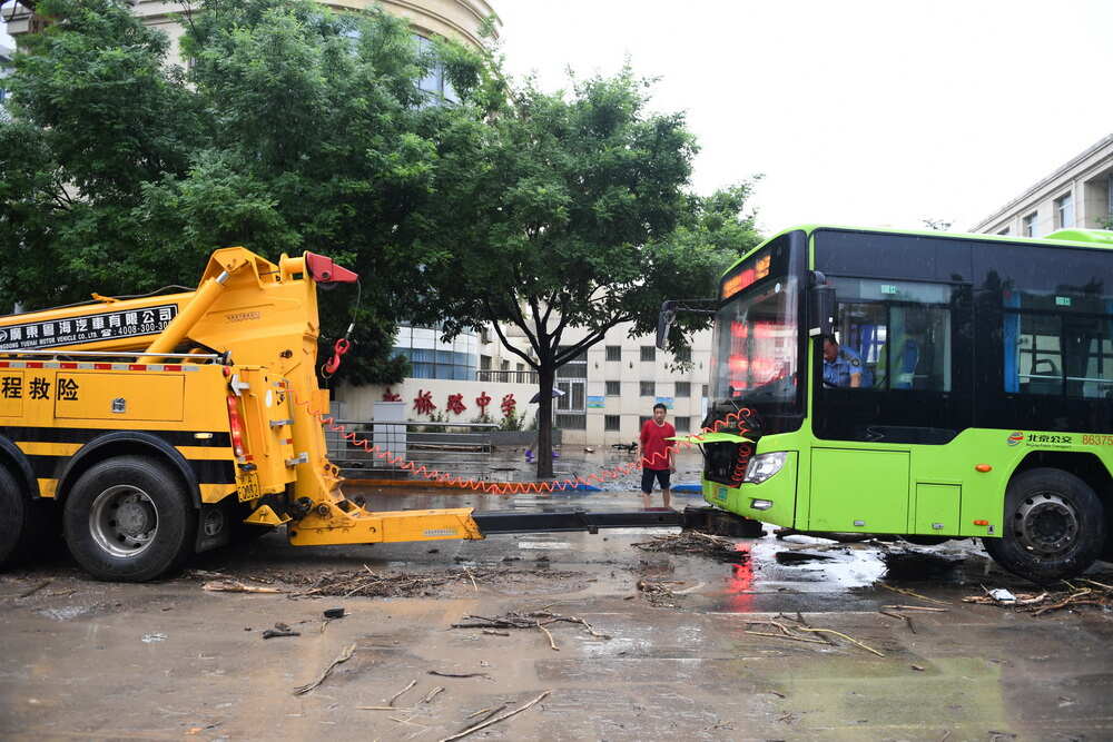 7月31日,抢险人员在北京市门头沟区新桥大街救援抛锚的公交车。新华社记者 鞠焕宗 摄 7月31日,抢险人员在北京市门头沟区新桥大街救援抛锚的公交车。新华社记者 鞠焕宗 摄