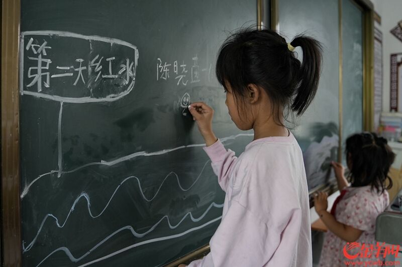 21日上午，清远市青莲镇青莲中心小学安置点，一年级女孩陈晓茵用粉笔画她目睹的洪水场景