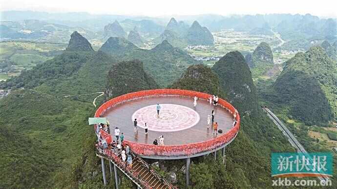 7月13日，游客在广西桂林市阳朔县如意峰观景（无人机照片）。新华社发